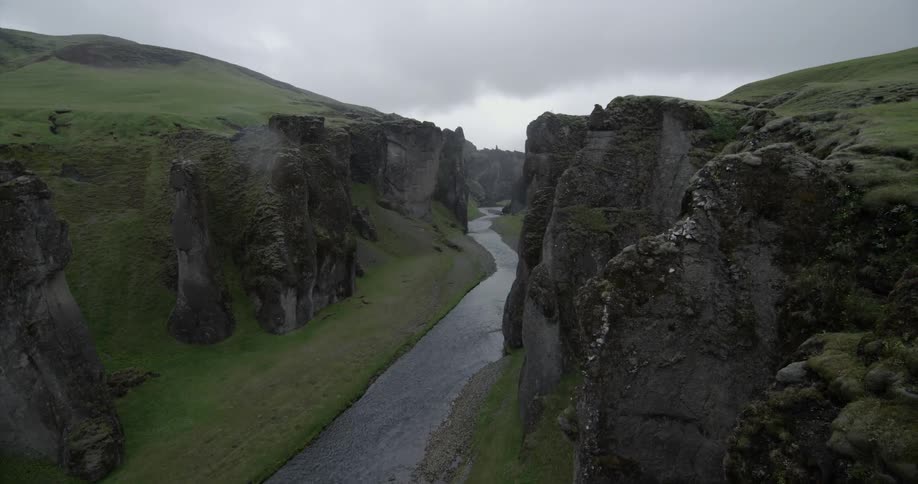 A river through a valley on a cloudy day