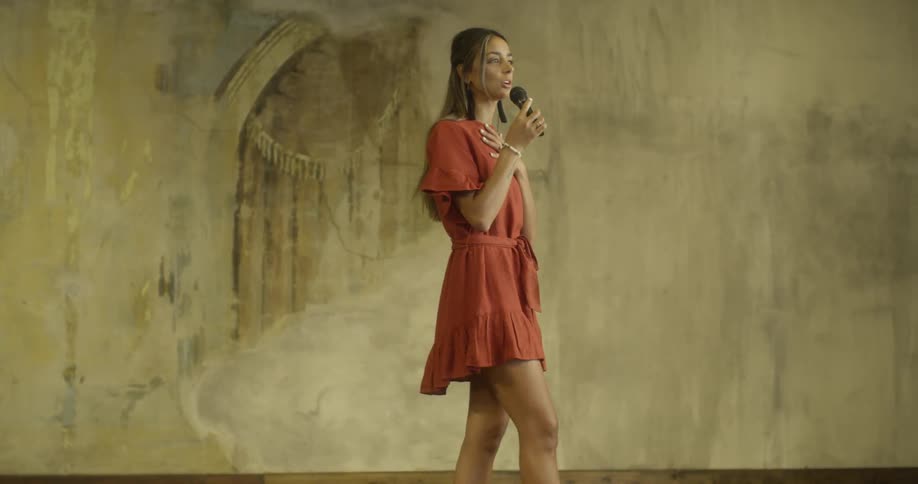 A woman is speaking on a stage during the day
