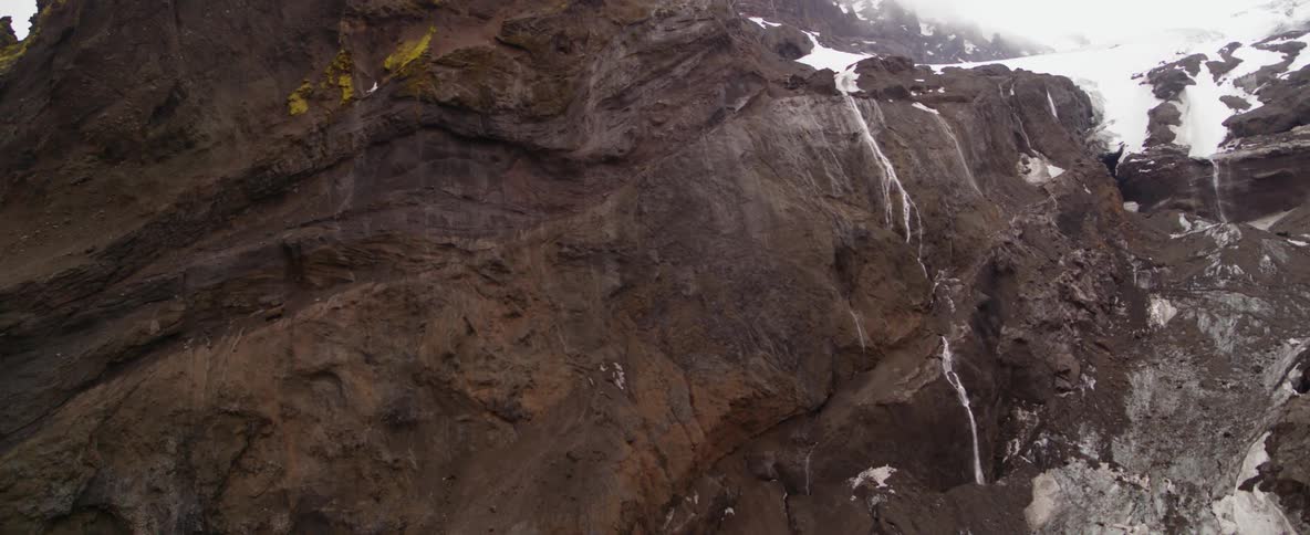 Water is falling down a rocky hillside and freezing on the way down