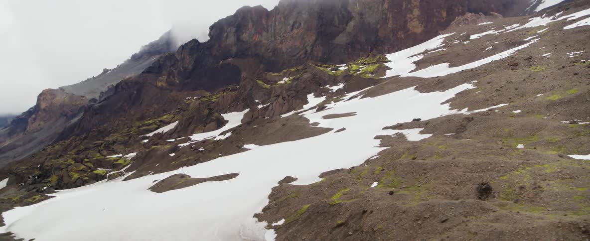 Snow covers a rocky mountainside