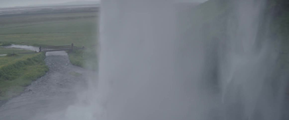 A waterfall gushes into a river