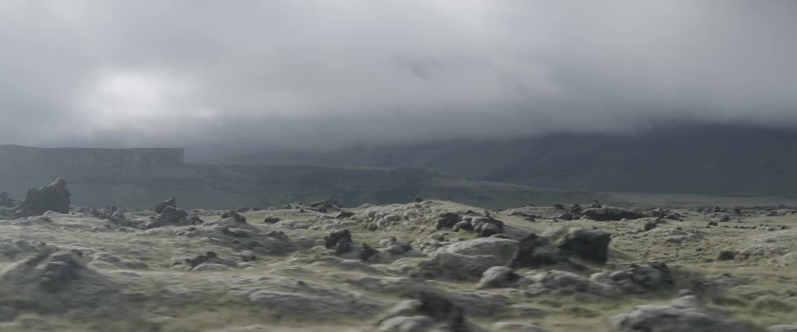 Clouds hang over rocky grasslands on a plateau on a stormy day