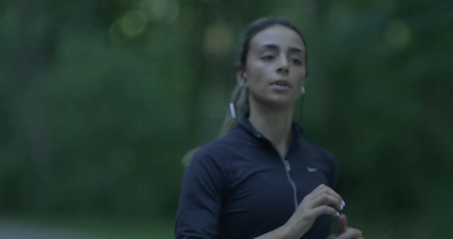 Woman jogs through a forested area