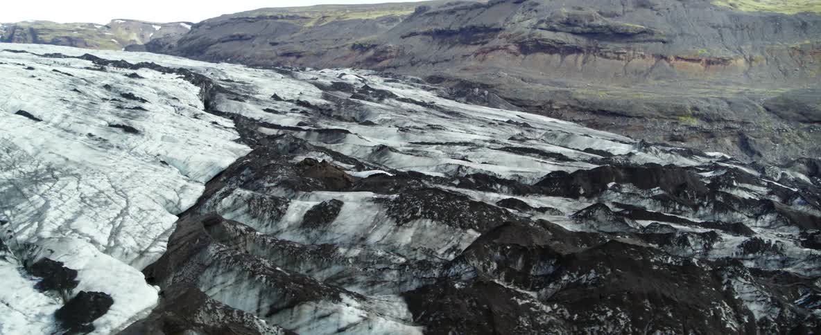A glacier covers the landscape in a mountain area during the day