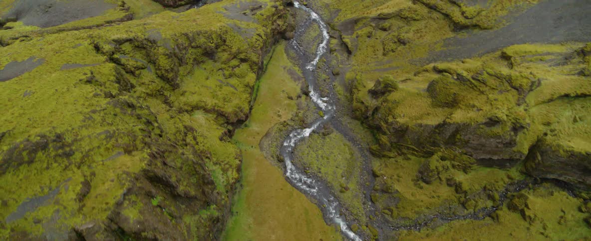 Water flows down a narrow stream between mountains