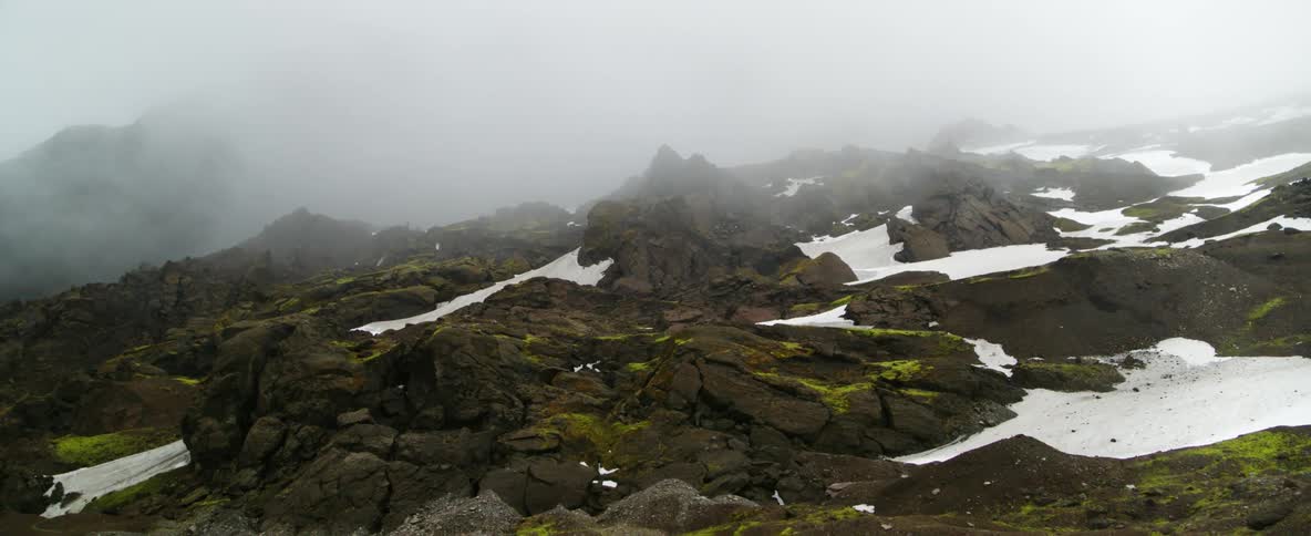 Fog floats above a snow covered mountain
