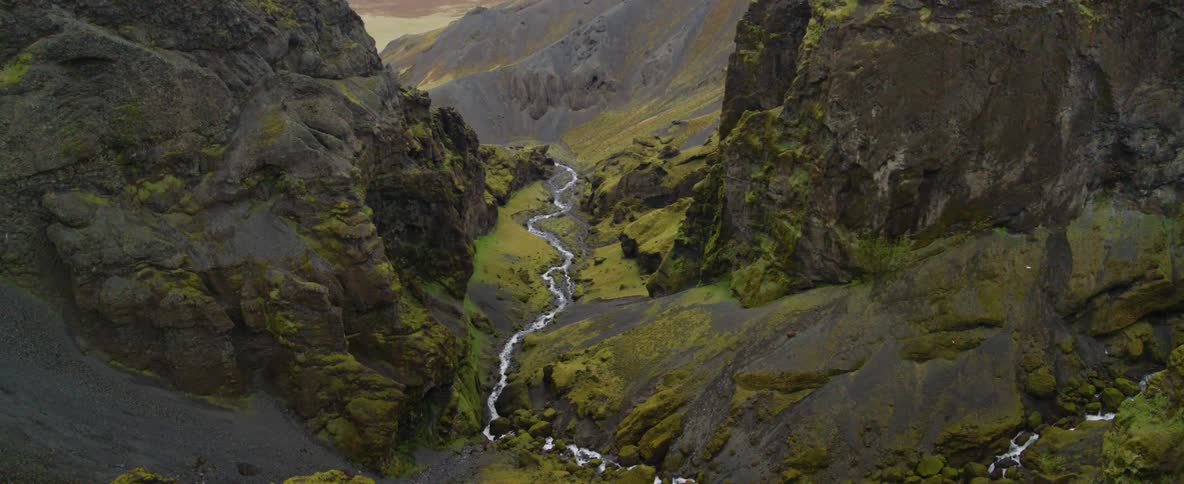 Water flows through a narrow stream between mountains