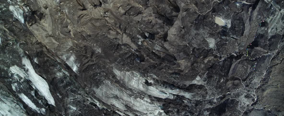 Snow and ice cover the stone mountain