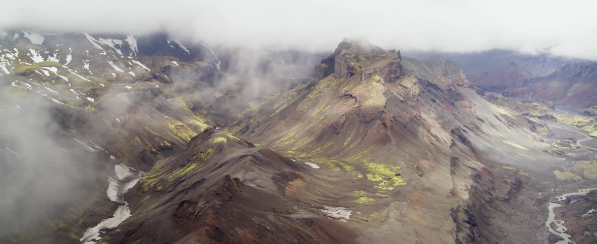 Clouds hover over a mountain ridge