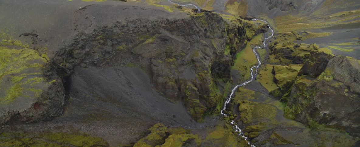 A river flows through mossy mountains