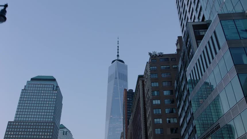 A skyscraper towers above a city at dusk