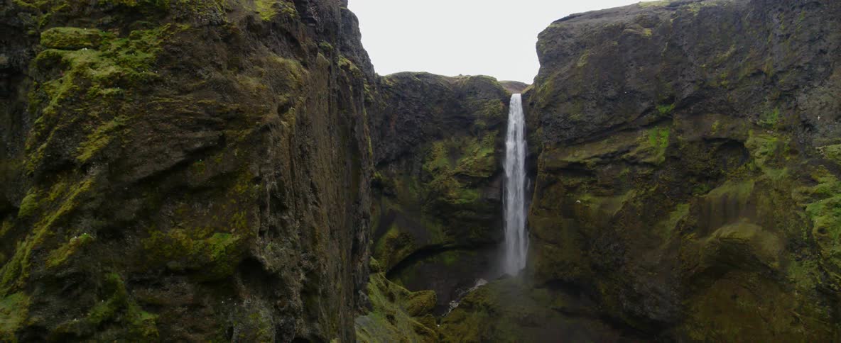 Water falls off the top of a stone cliff