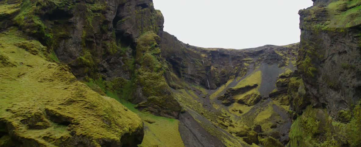 A river is flowing rapidly through a mountain ravine during the day