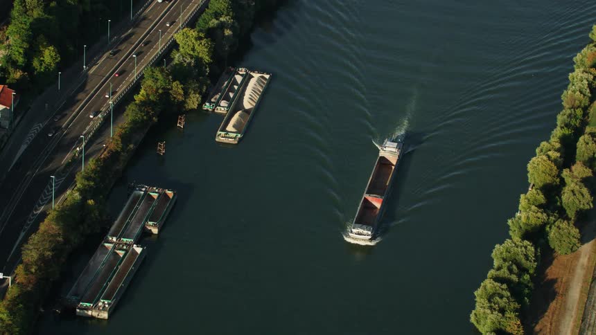 A boat travels down the waterway next to the road