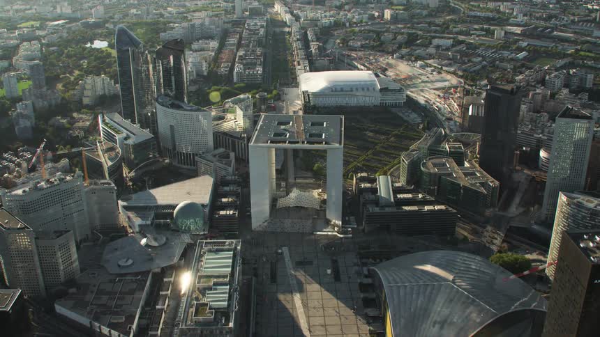 A large city is being flown over showing many oddly shaped buildings