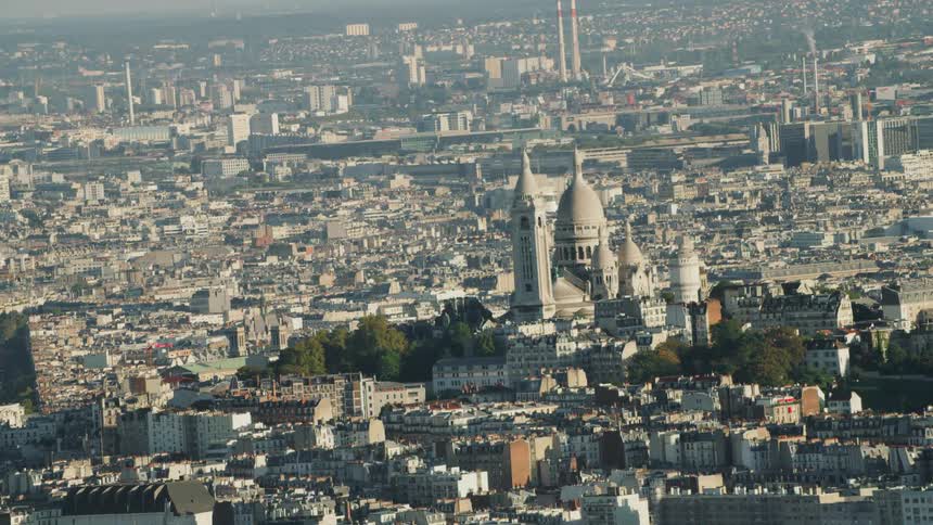 City buildings cover a hilly landscape with Sacr��-C��ur de Montmartre