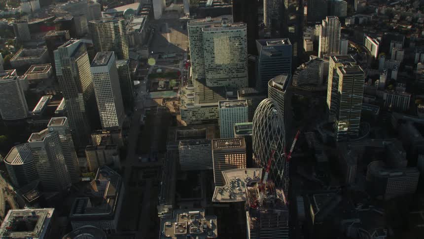 The buildings are tall with cars traveling on the roads below