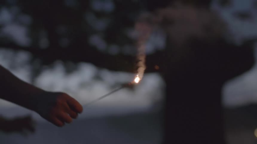 Child running with a sparkler at night