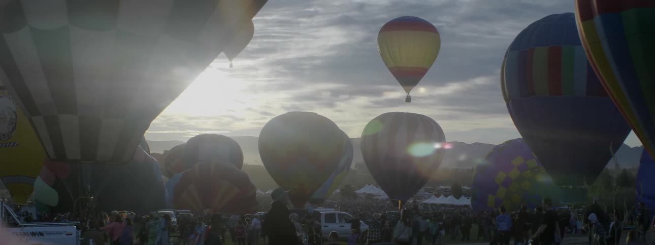 Hot air balloons begin to float up into the sky