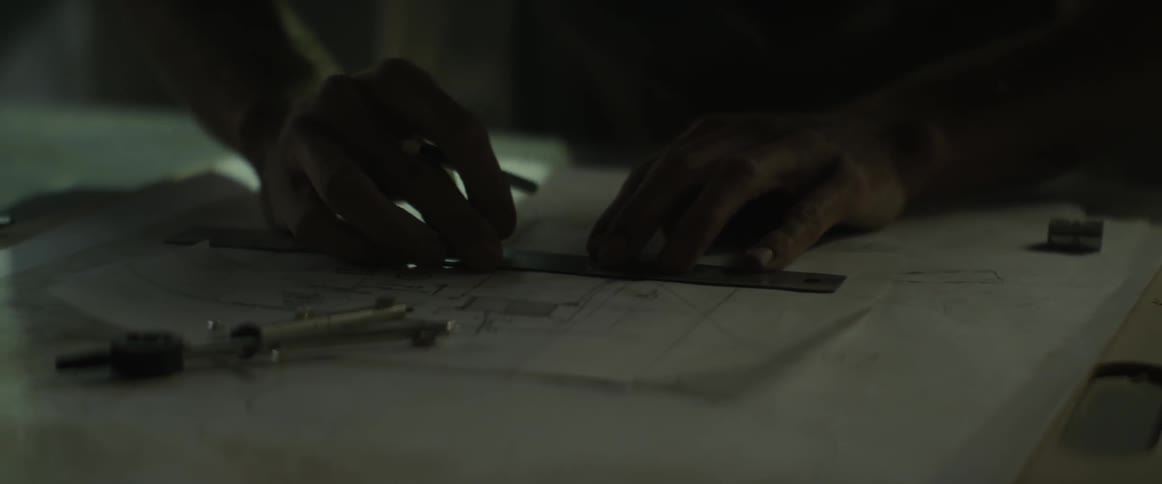 A man draws on blueprints