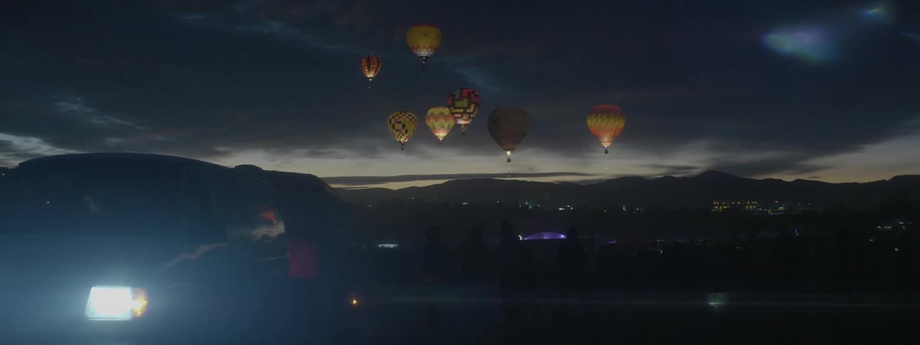 Hot air balloons are lifting off at night