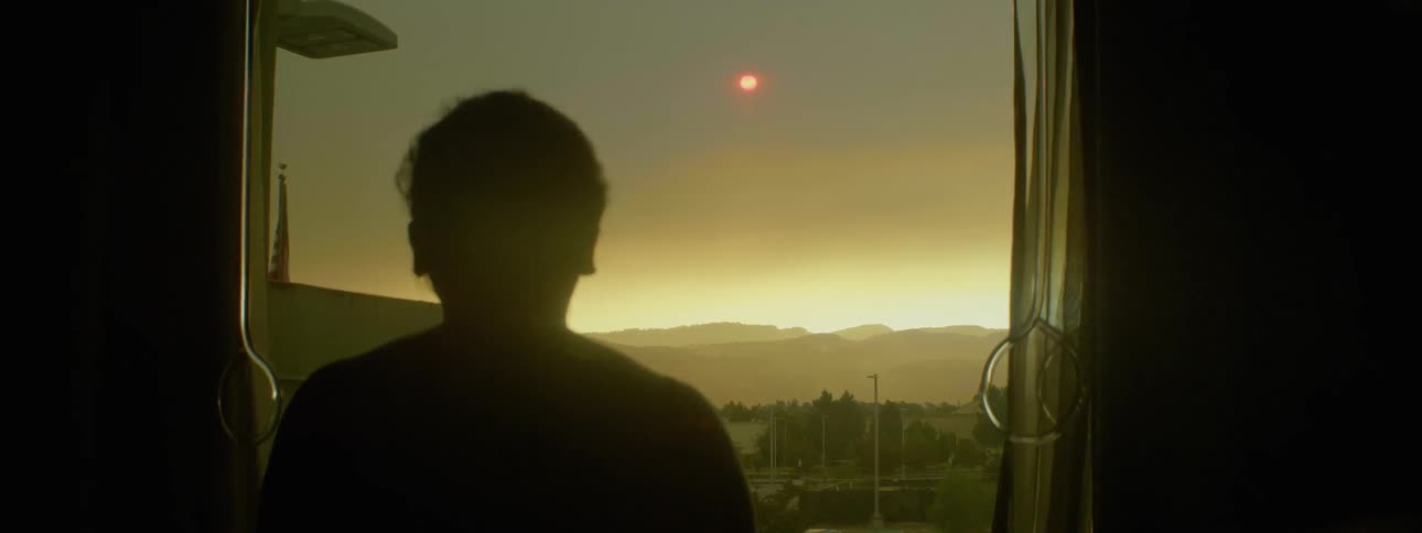 A man opens the curtains
