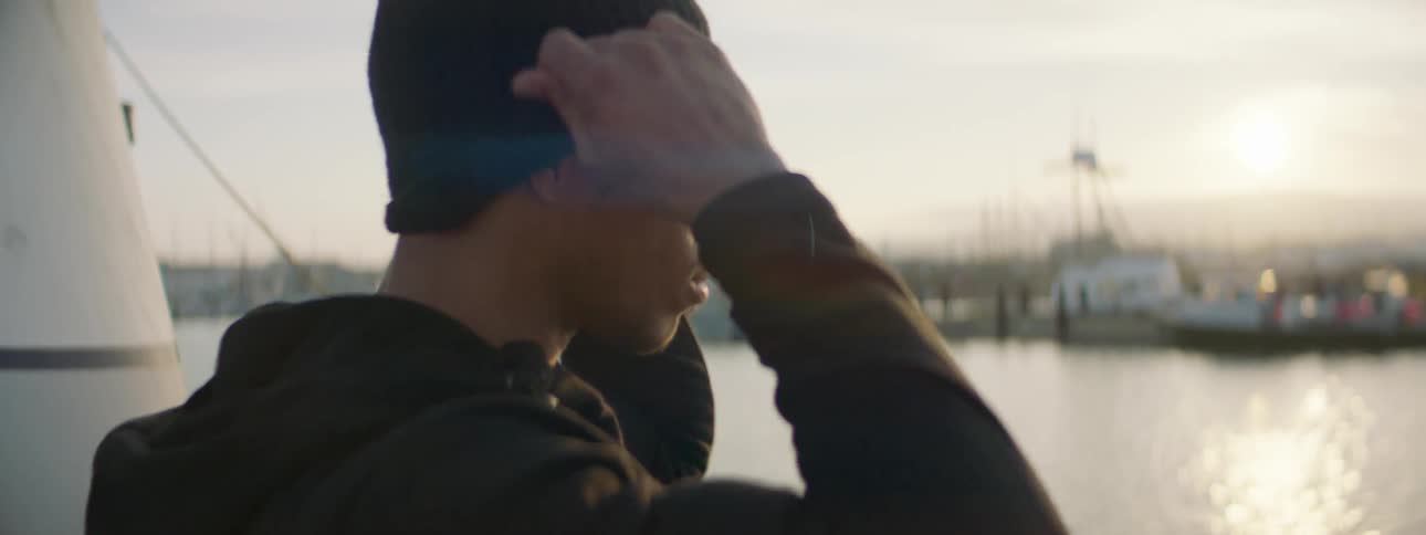 Man standing on a boat puts on a skull cap