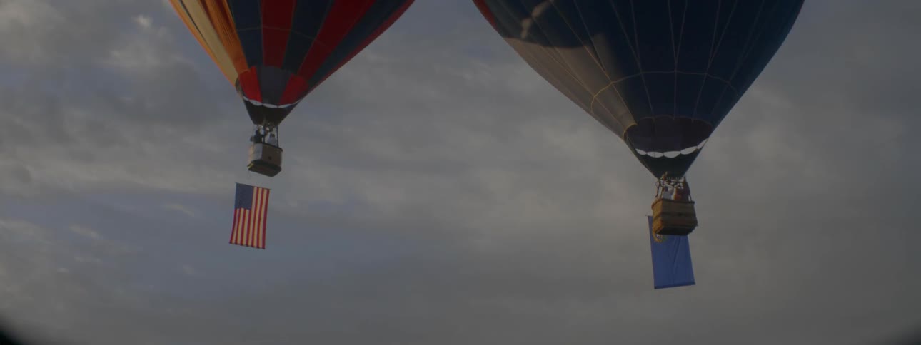 Flags hang from floating hot air balloons