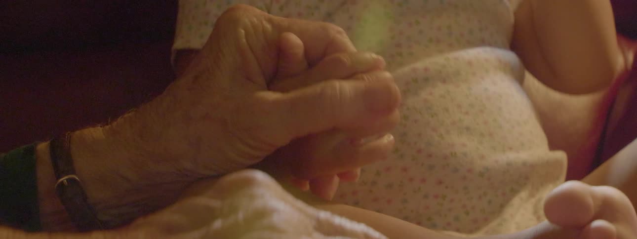 A person rubs the hand of a baby