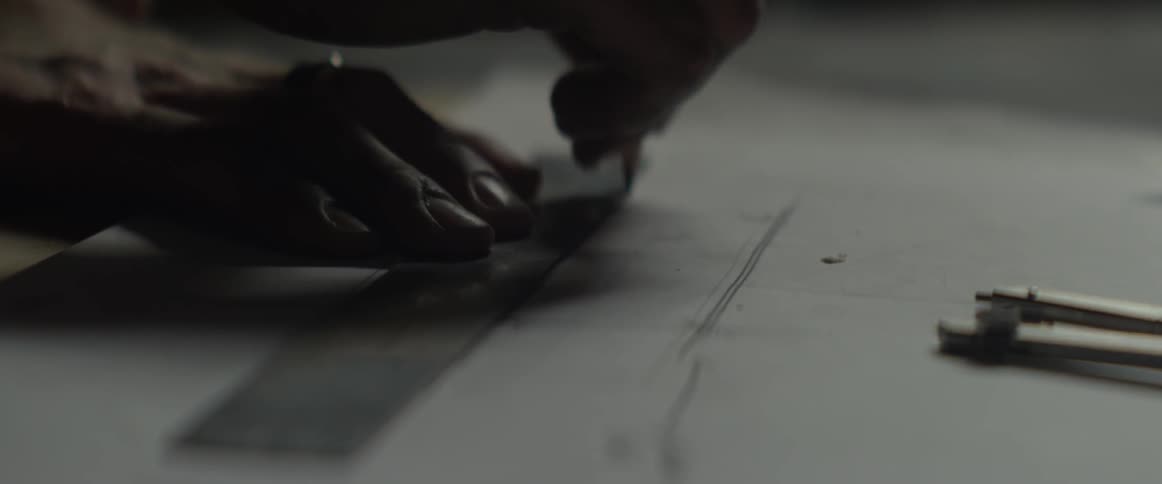 A man marks lines on blueprints