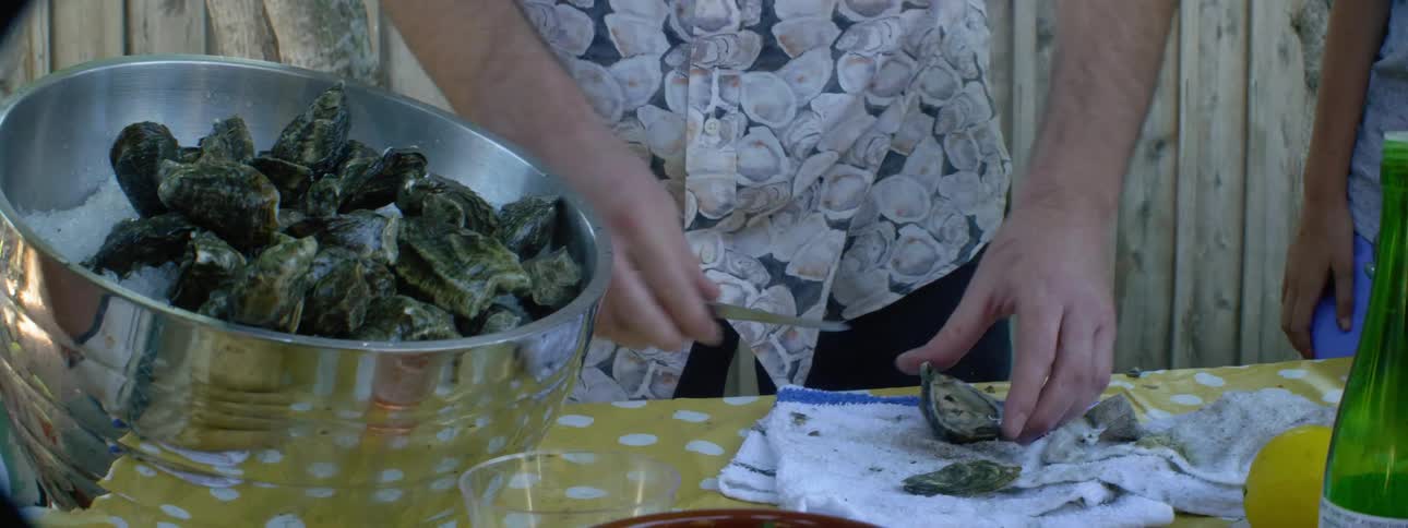 A man opens up oyster shells