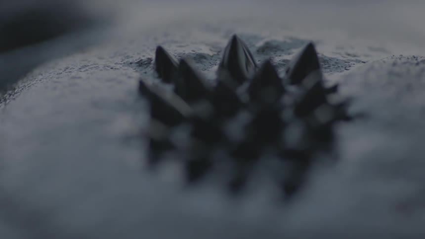 Black liquid ripples up into a spiked pattern