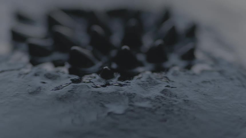 Black liquid ripples up into a spiked pattern