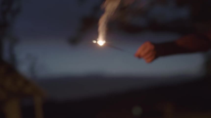 A boy lights a sparkler and runs with it