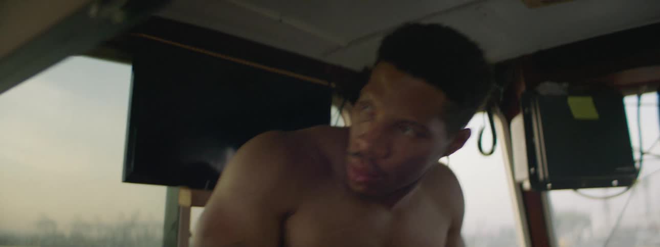 A man wakes up in a boat bunk and sits up