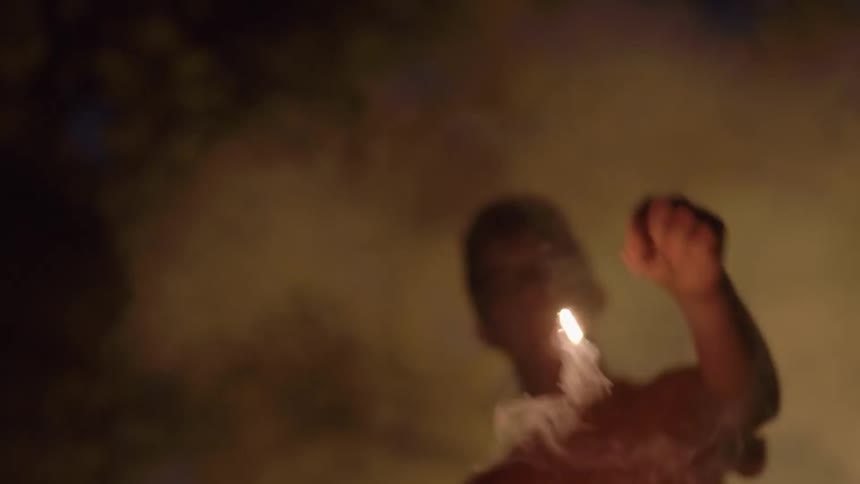 Child waving a sparkler around in the dark