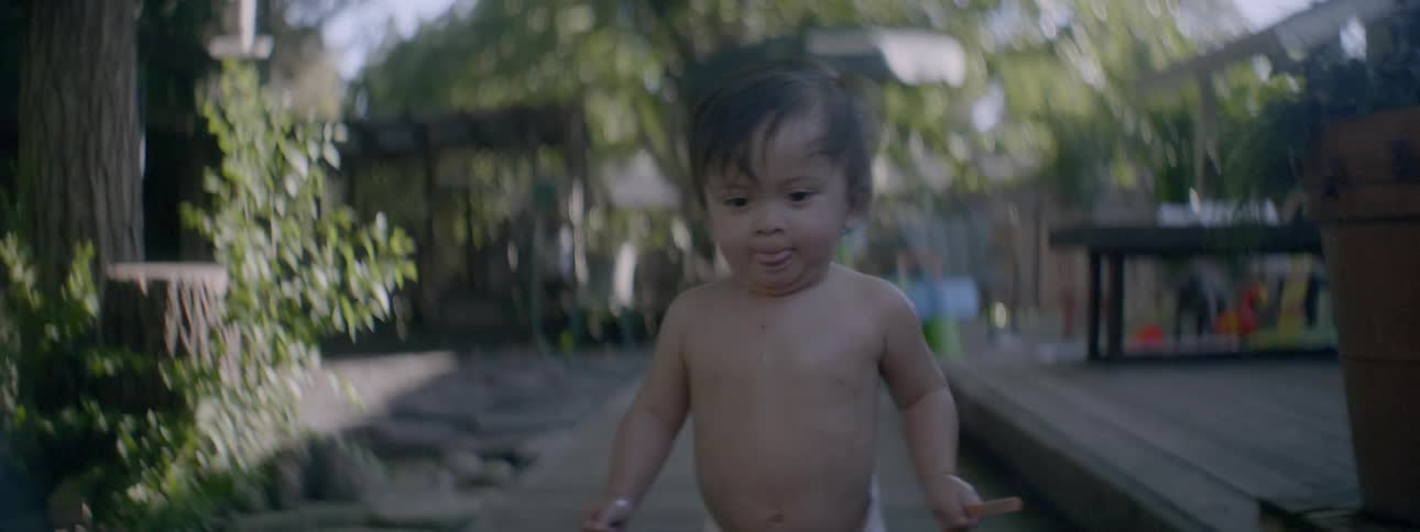 A baby is walking out on the porch