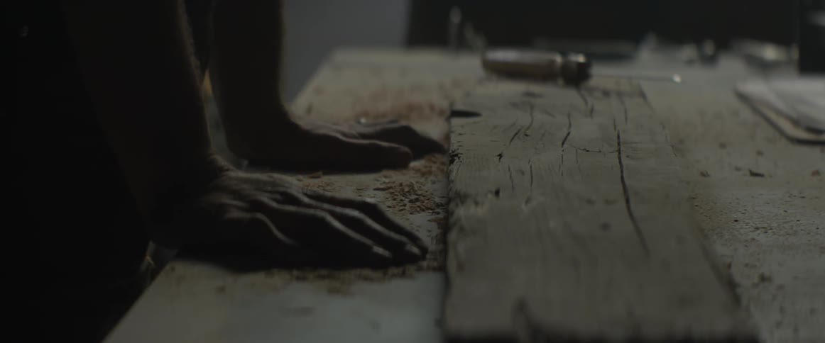 A man puts his hand down on a table in a workshop