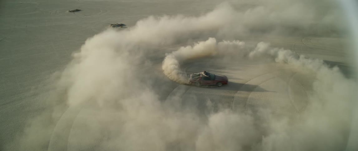 A man rides on a vehicle doing donuts in the desert