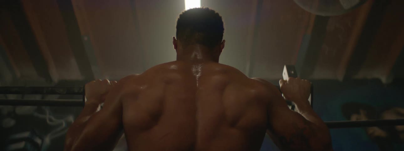 A man does pull ups in a gym