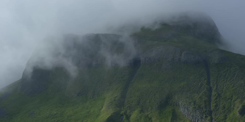 Clouds float around a mountain