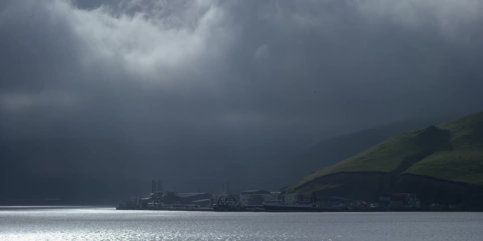 A mountainside ocean dock on a cloudy day
