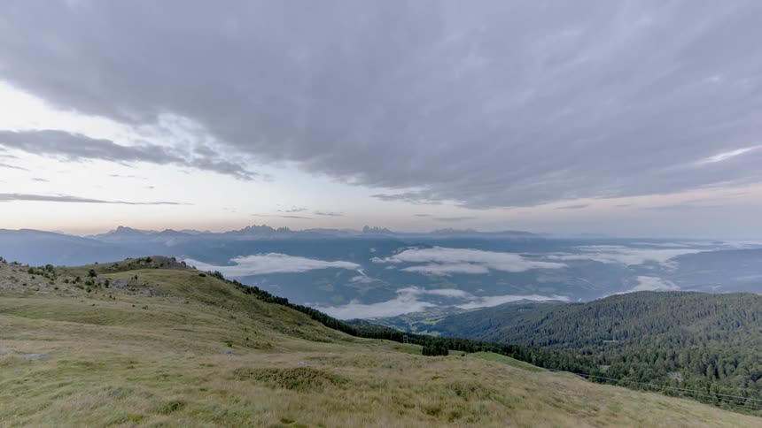 Clouds pass over mountains at sunrise