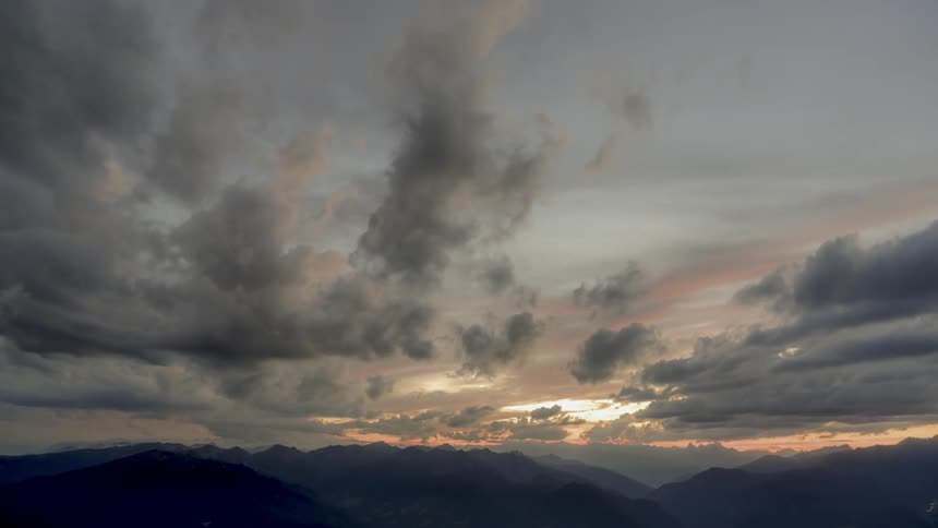 Dark clouds pass above the mountains