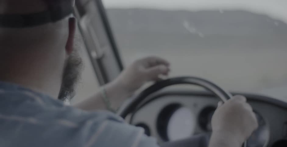A bearded man drives a boat