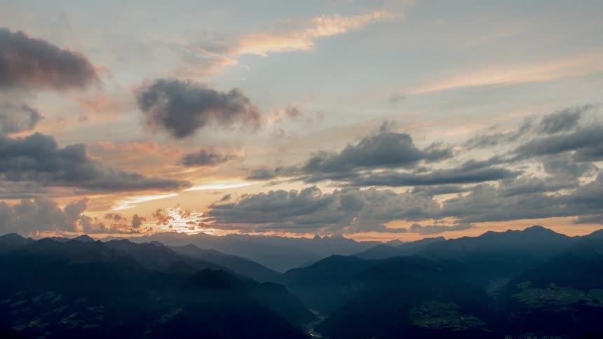 Clouds float over a mountain range at sunset