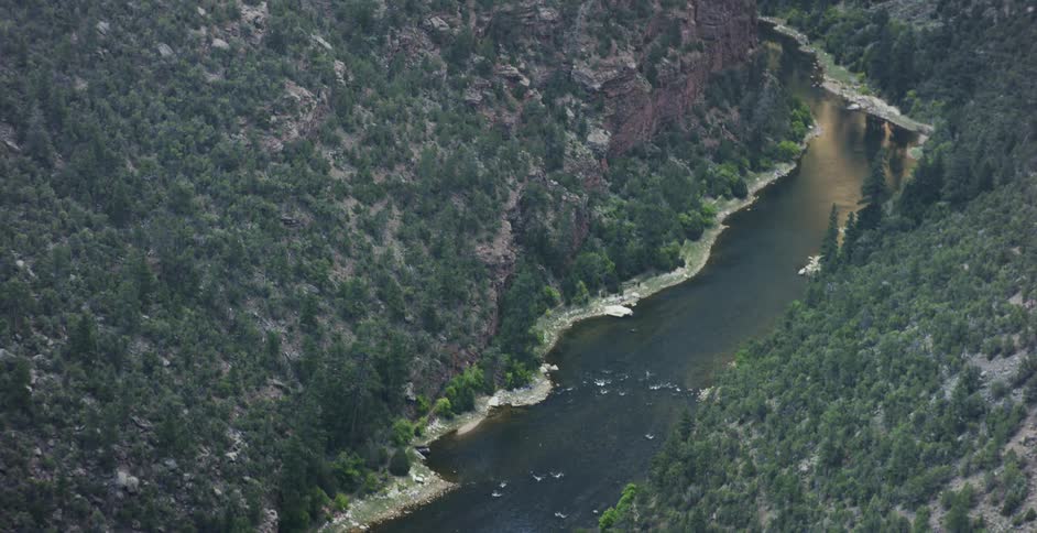 A river runs through these tree covered hills