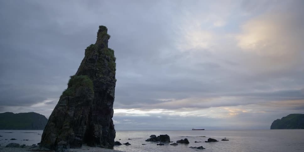 Waves crash against rock formation in water