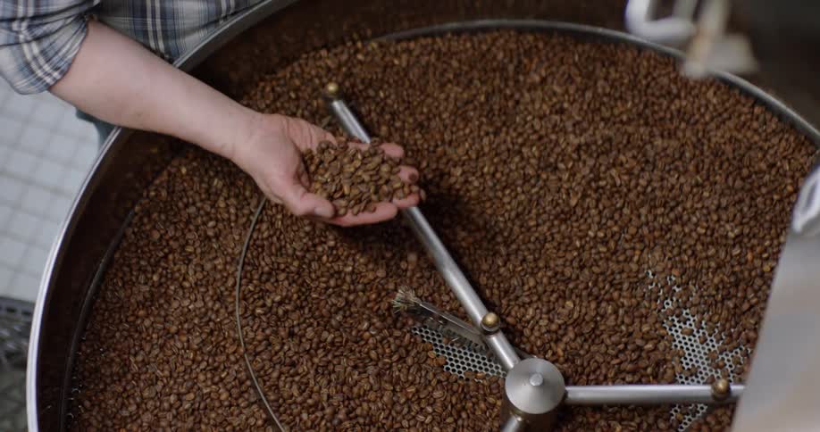 A machine is turning and roasting coffee beans