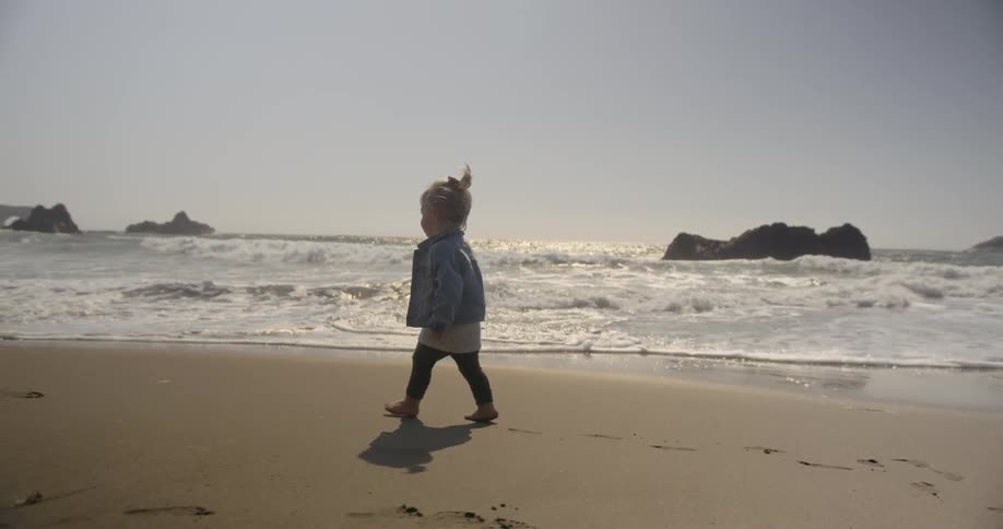 A child walks on the beach on a sunny day